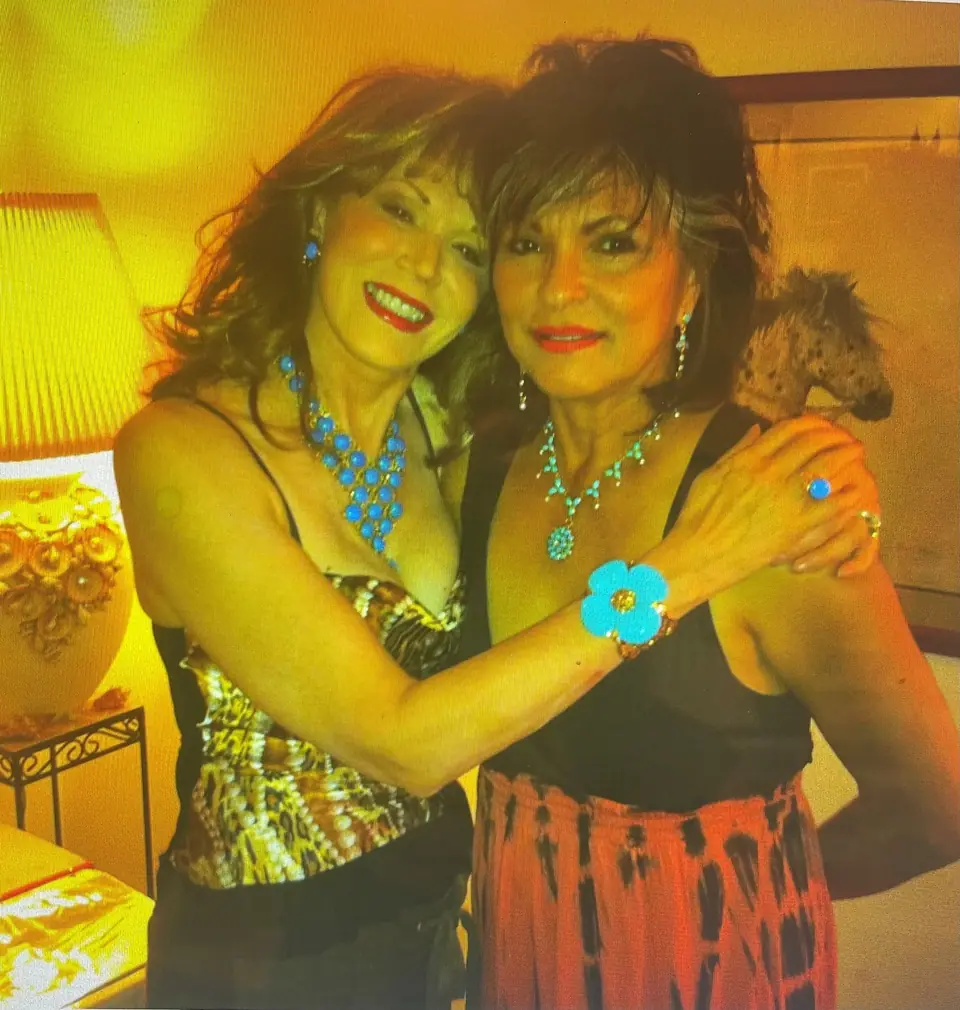 Two women embracing, wearing Swoboda turquoise necklaces, earrings and a turquoise flower bracelet