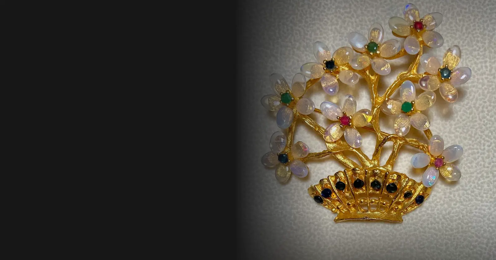 A Swoboda flower-basket brooch of opal, sapphire, ruby and emerald in 24k gold plate